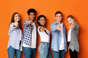 group of teens pointing forward and smiling after attending the teen outpatient program in Tampa