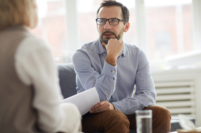 A well-dressed male professional speaking to his counselor in one of our executive drug rehab centers