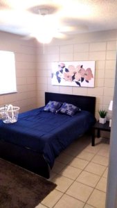 made bed with tiled room and art on the walls at boardprep recovery