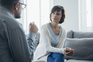 woman at alcohol rehab for physicians listening to therapist at alcohol rehab for physicians in tampa fl