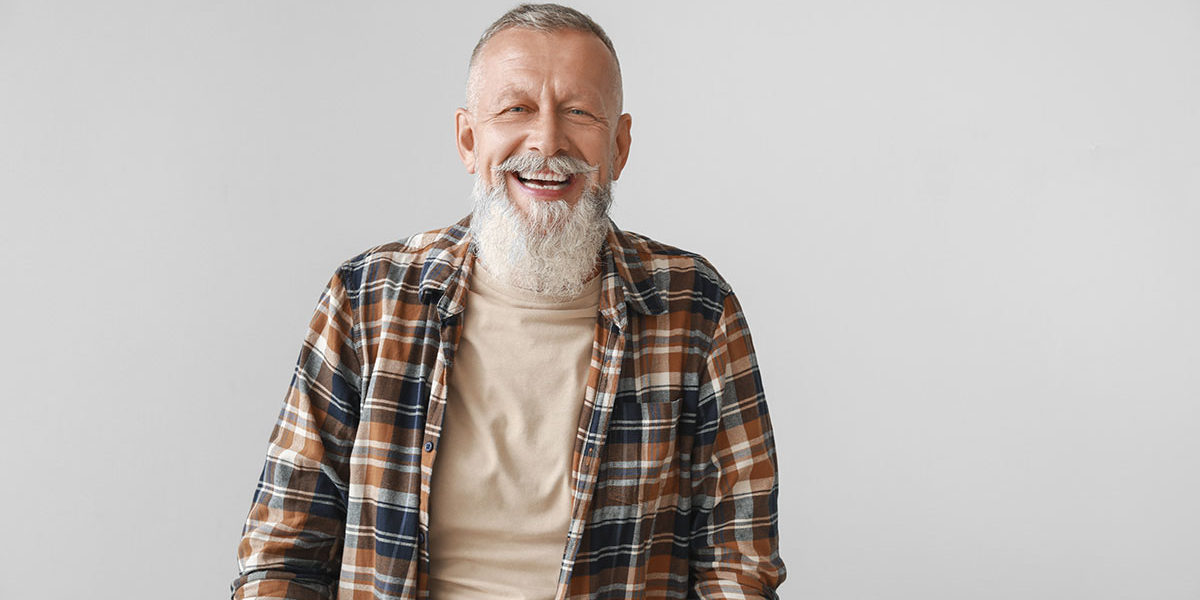 bearded man smiling after learning how can addiction treatment help me