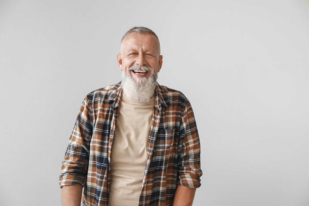 bearded man smiling after learning how can addiction treatment help me