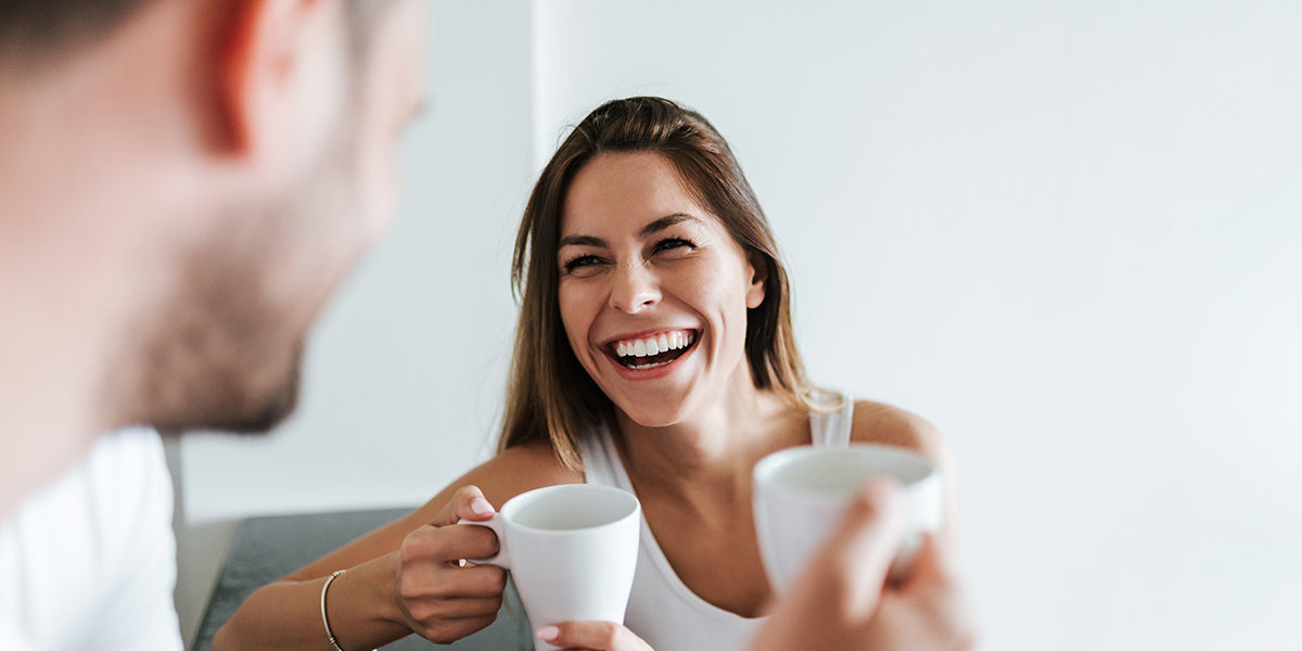 woman laughing over coffee with husband as they apply the recovery rehab principles