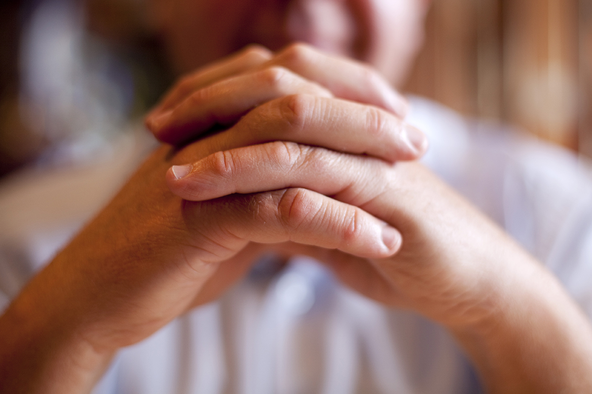 person with hands clasped dealing with complacency in recovery