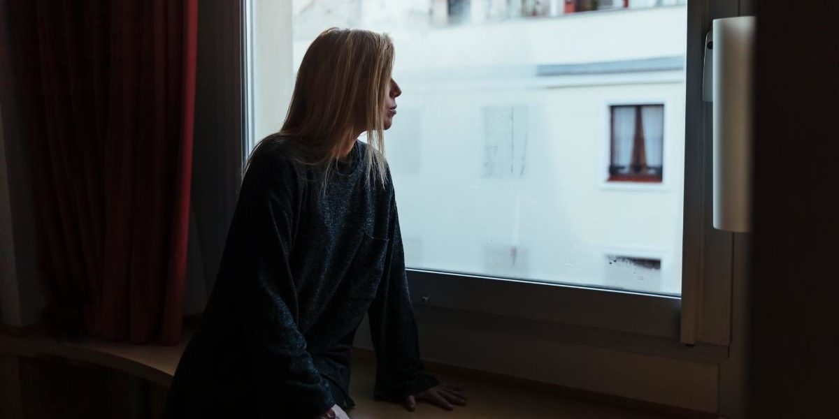 a woman looking out her window thinking about how she is a professional in recovery