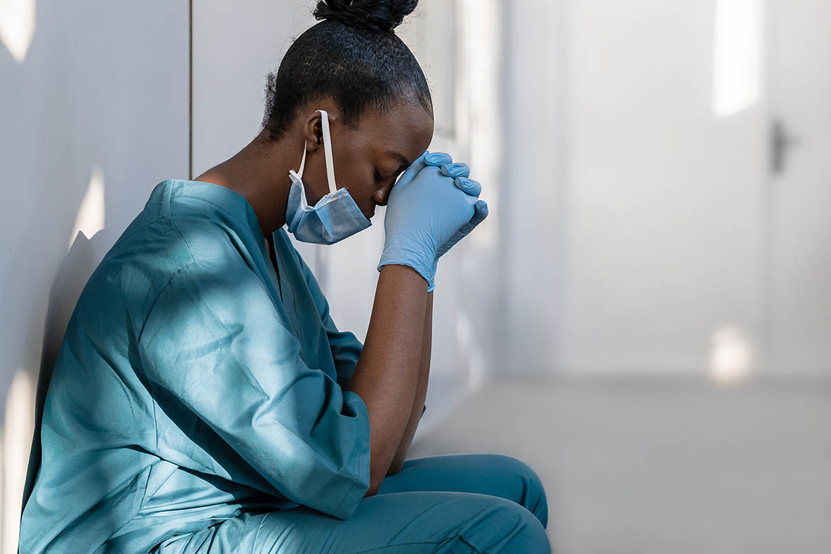 How Addiction’s Effects on Healthcare Professionals Extend to Their Patients A stressed nurse crouching to the floor