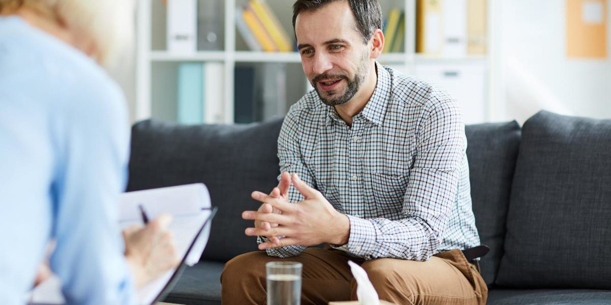 man in alcohol rehab for professionals discussing how to quit drinking with his counselor