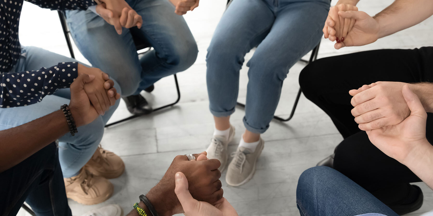 Hands of people sitting in a circle at a heroin rehab in Tampa
